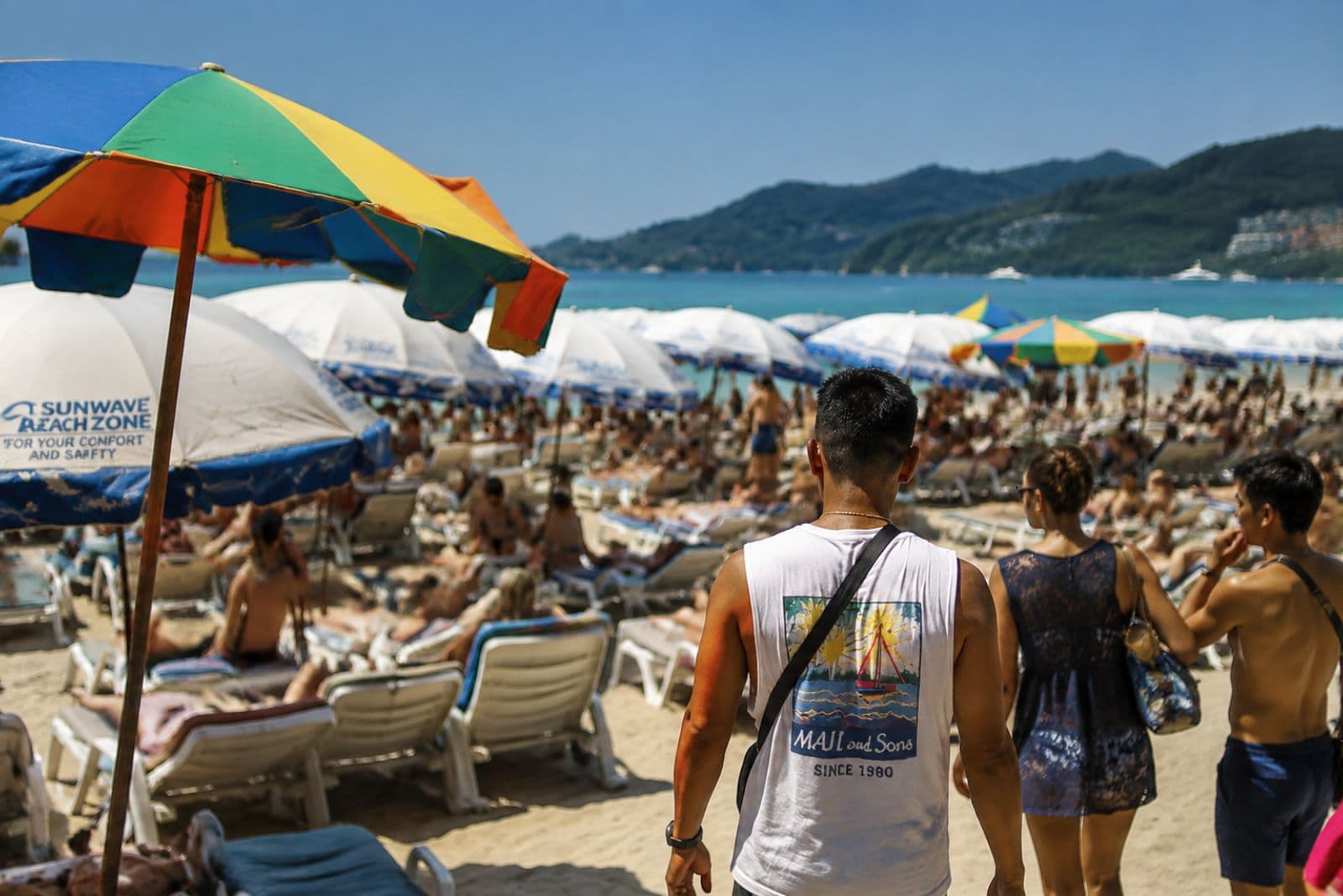 Crowded Patong beach with umbrellas and sunloungers